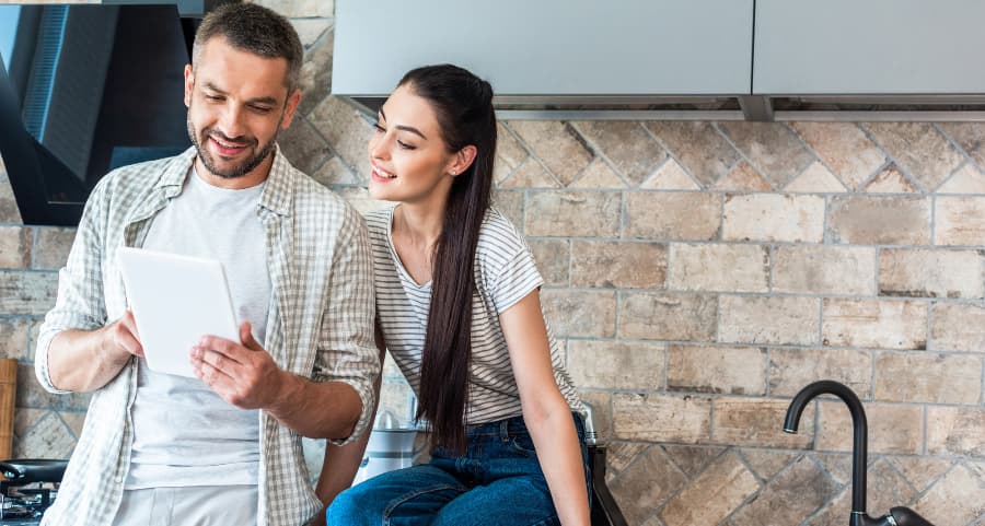 Young couple using a mobile device together to control smart home