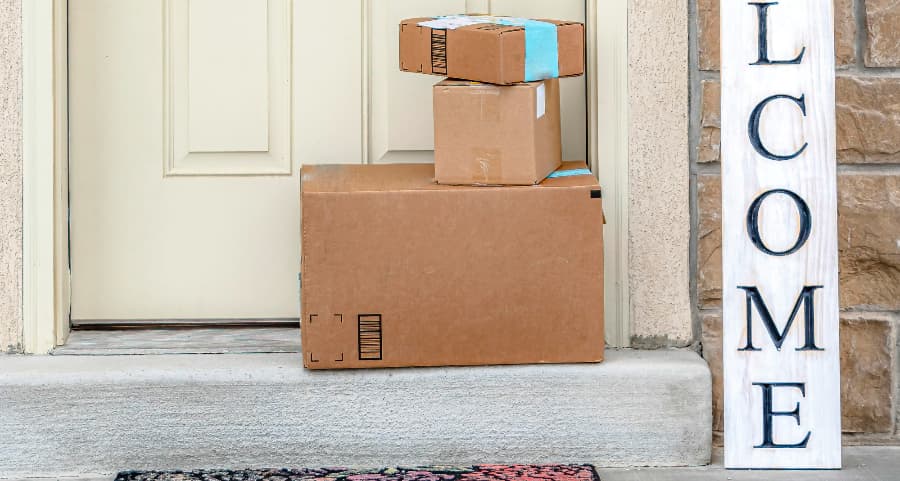 Packages on the doorstep of a home with a welcome sign in Kennewick